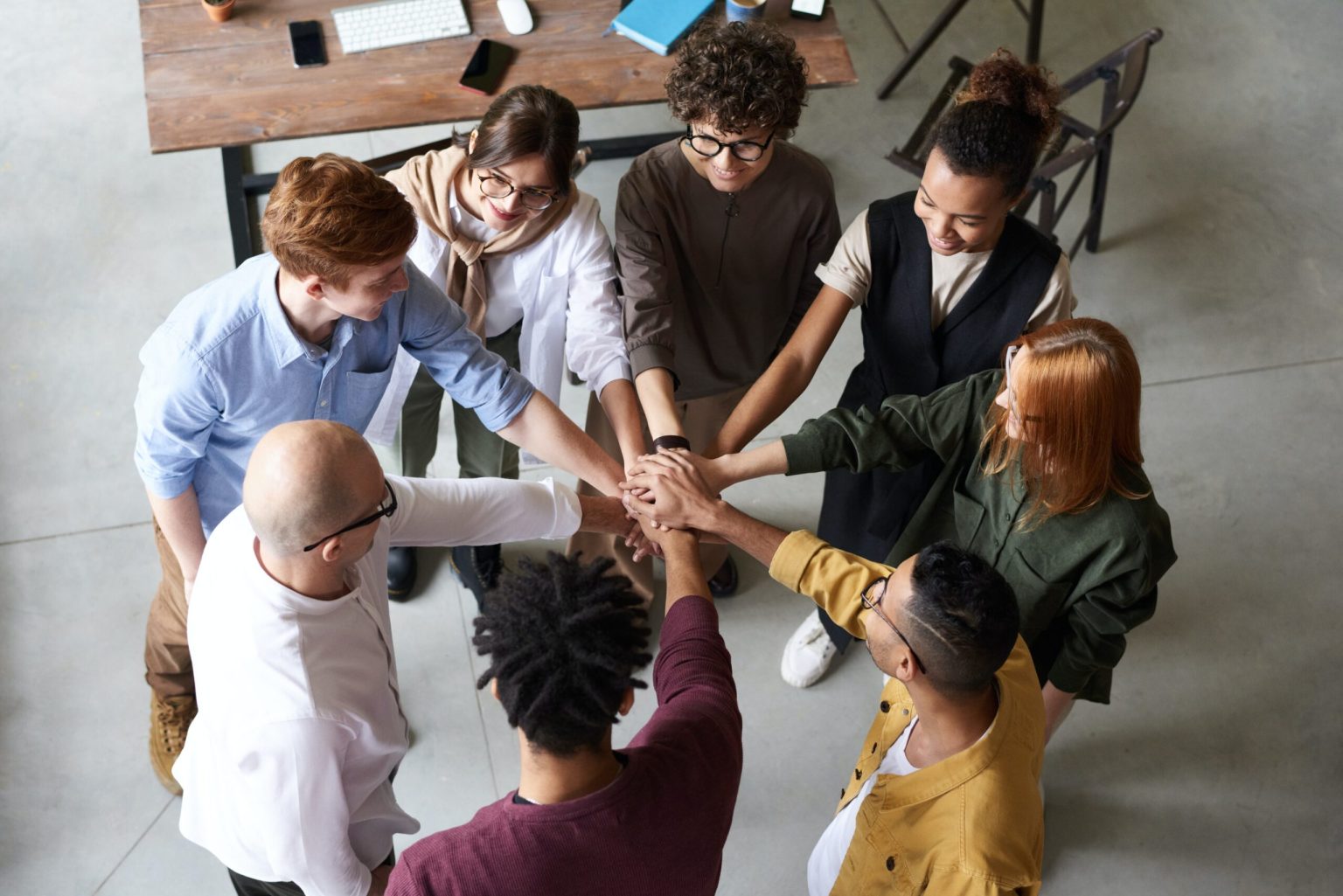 Team with their hands in the middle of the group.