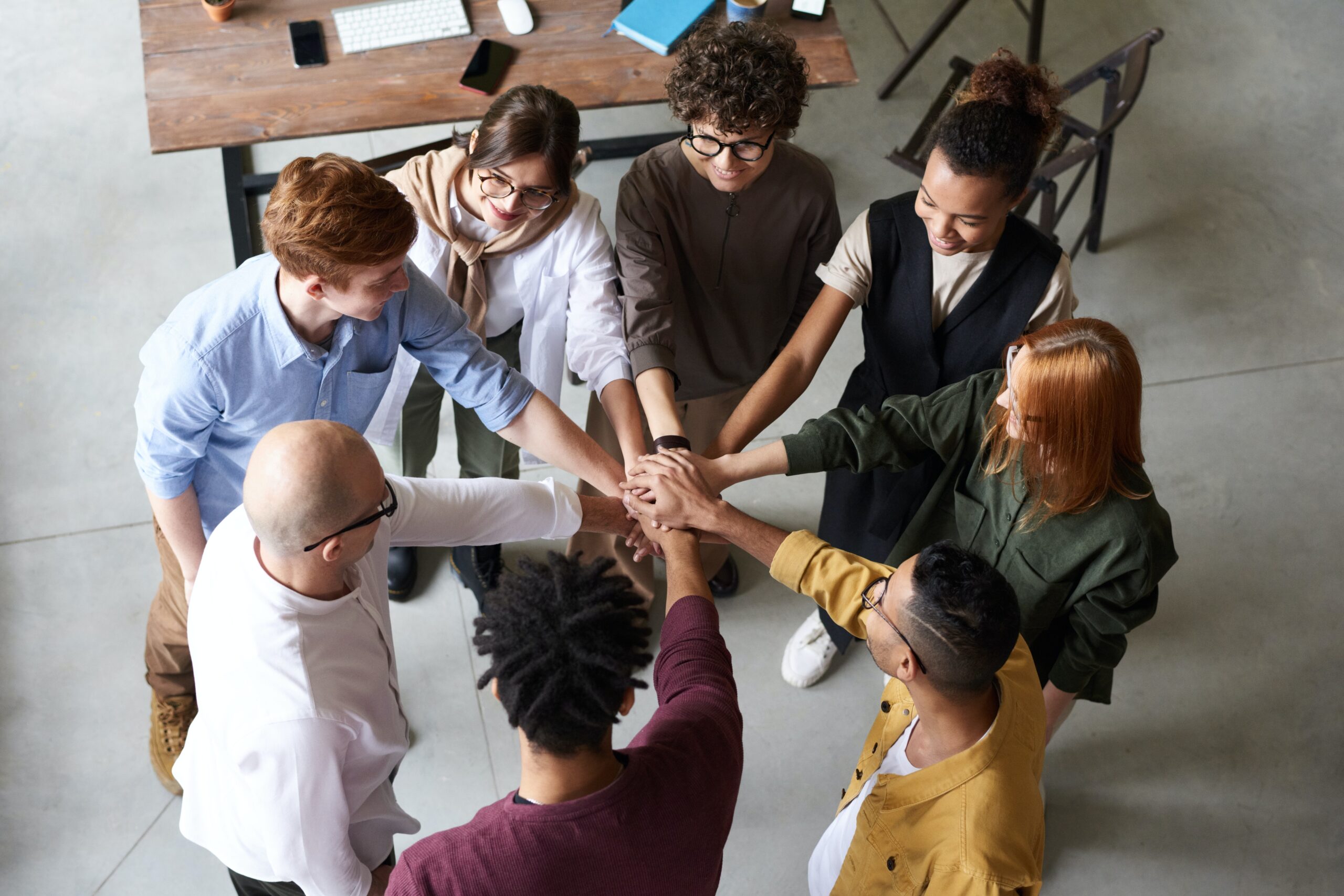 Team with their hands in the middle of the group.