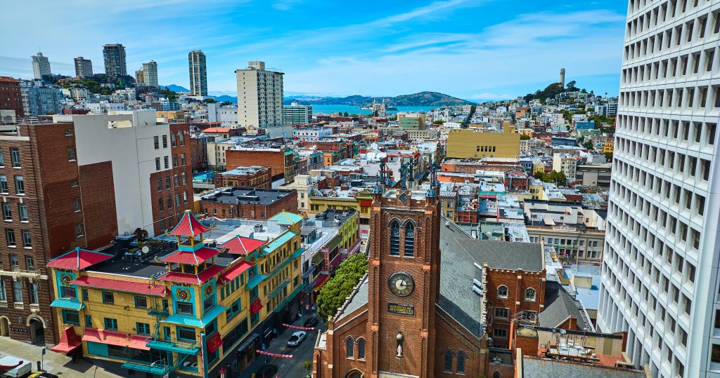 Drone arial photo view of Chinatown with Coit Tower and San Francisco Bay in the distance